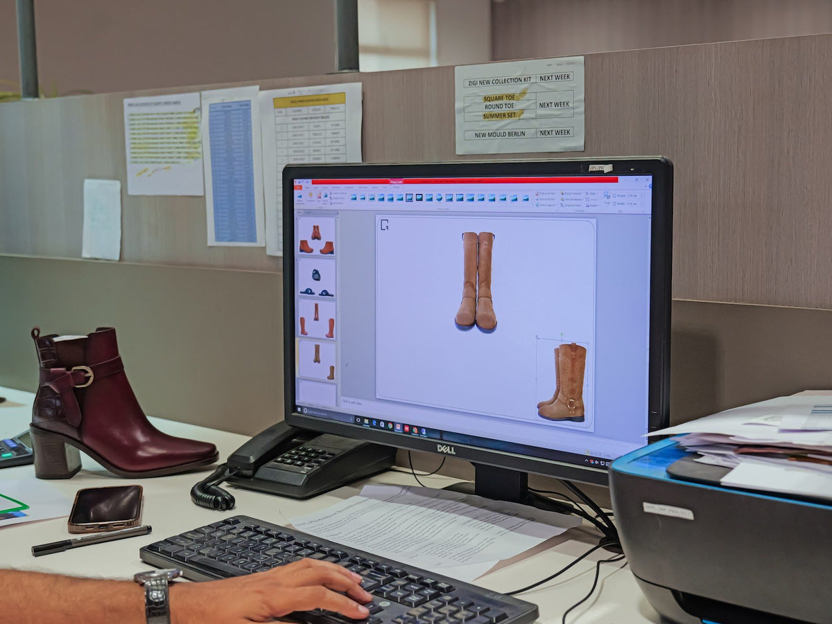 Boot designs reviewed on screen in the AFPL Product Creation Centre, with a sample on the desk