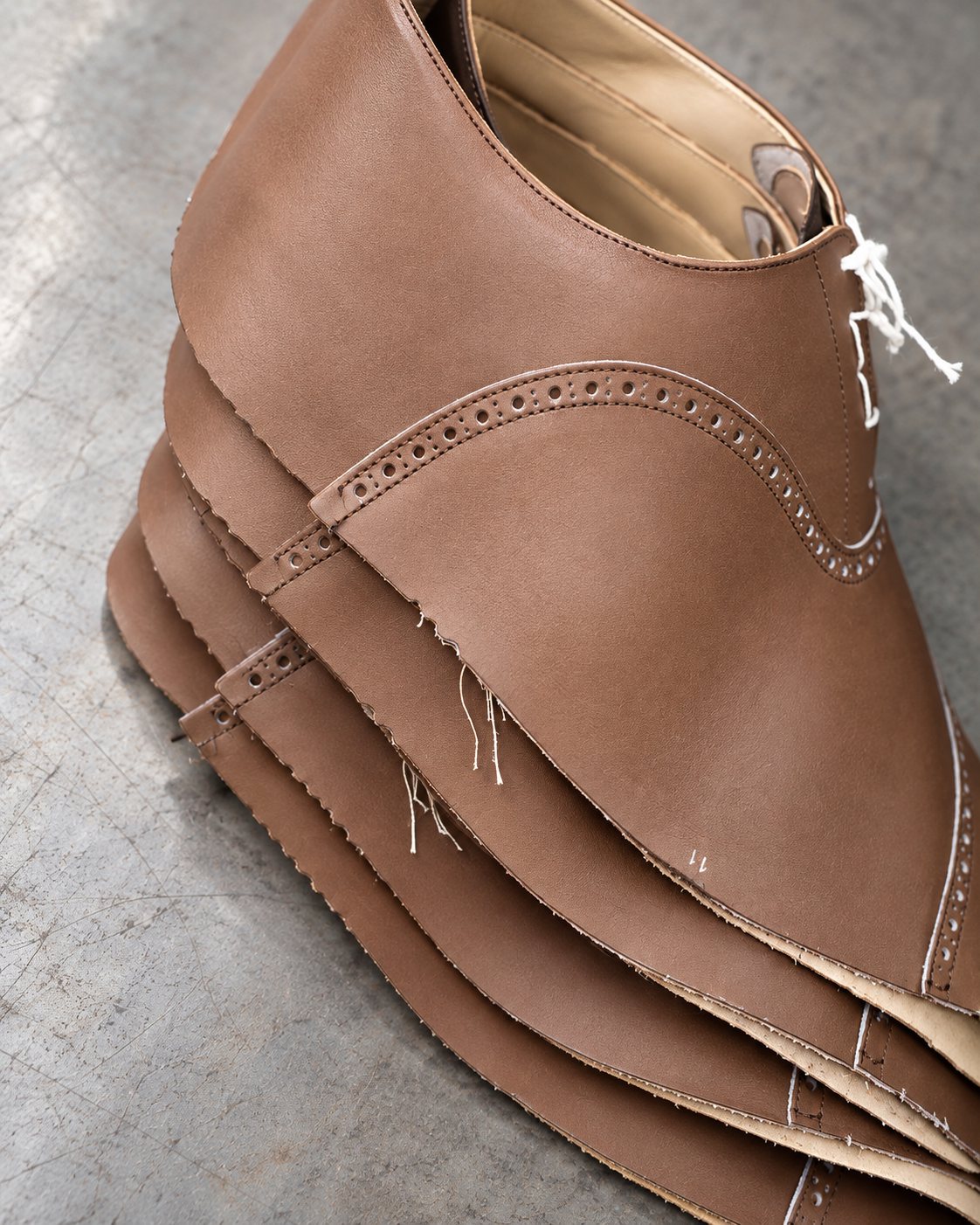Brown leather brogue uppers, stacked after closing