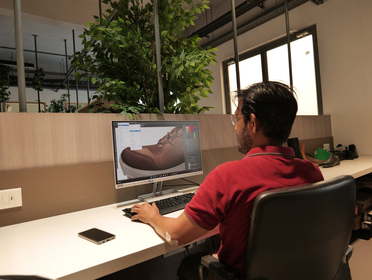 A designer working on a shoe in 3D at a CAD workstation