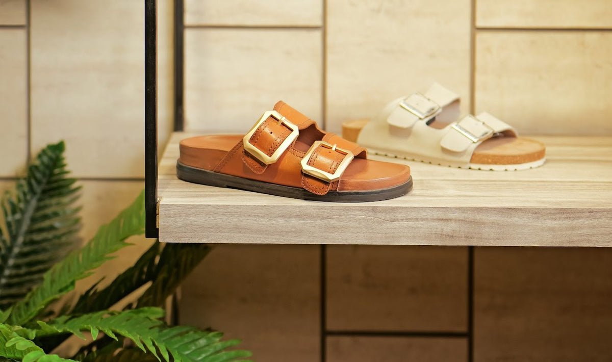 Double-buckle leather sandals on a showroom shelf