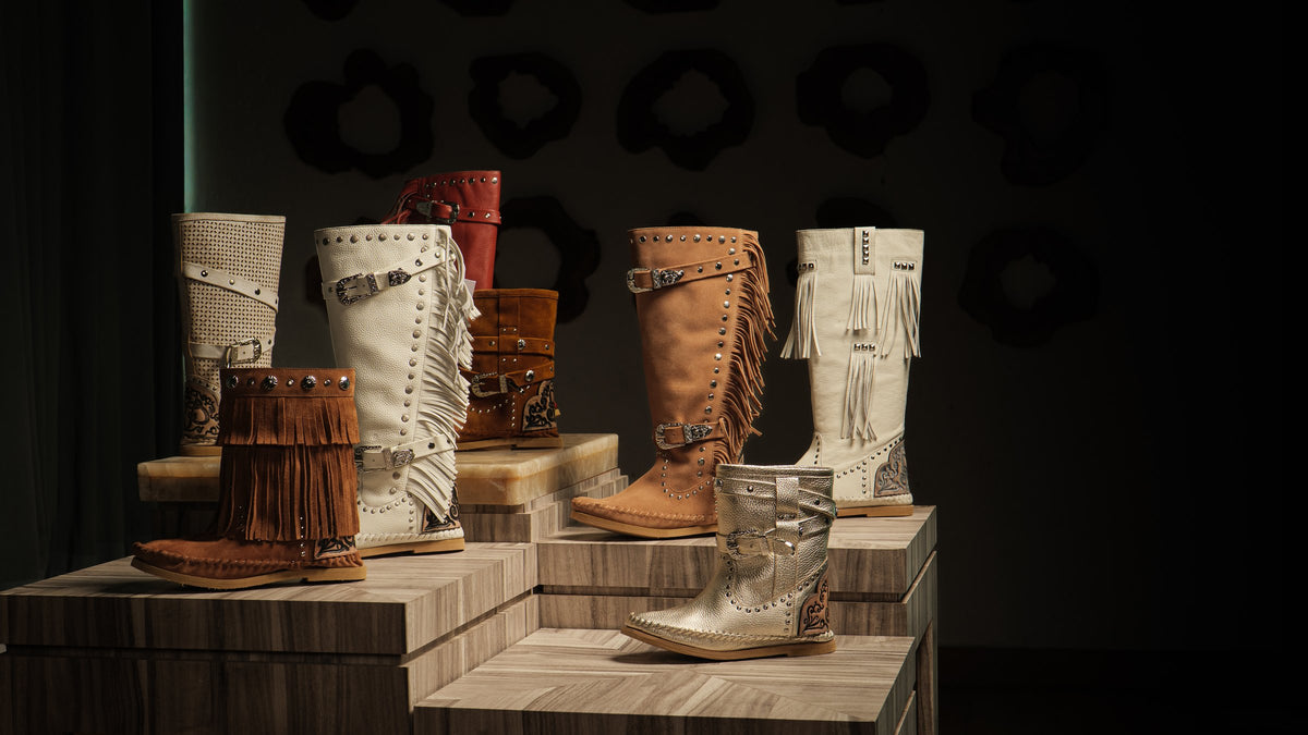 A fringed and studded boot collection on display plinths