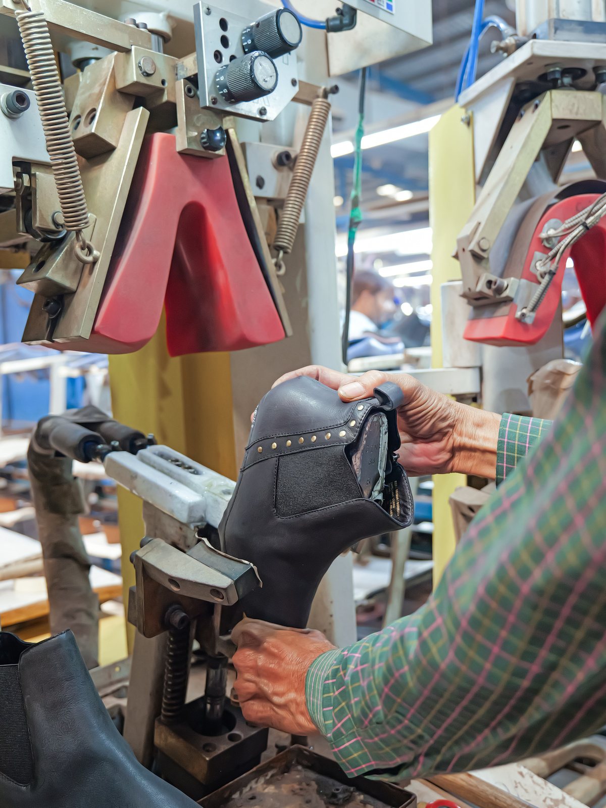 An operator lasting a boot on a lasting machine