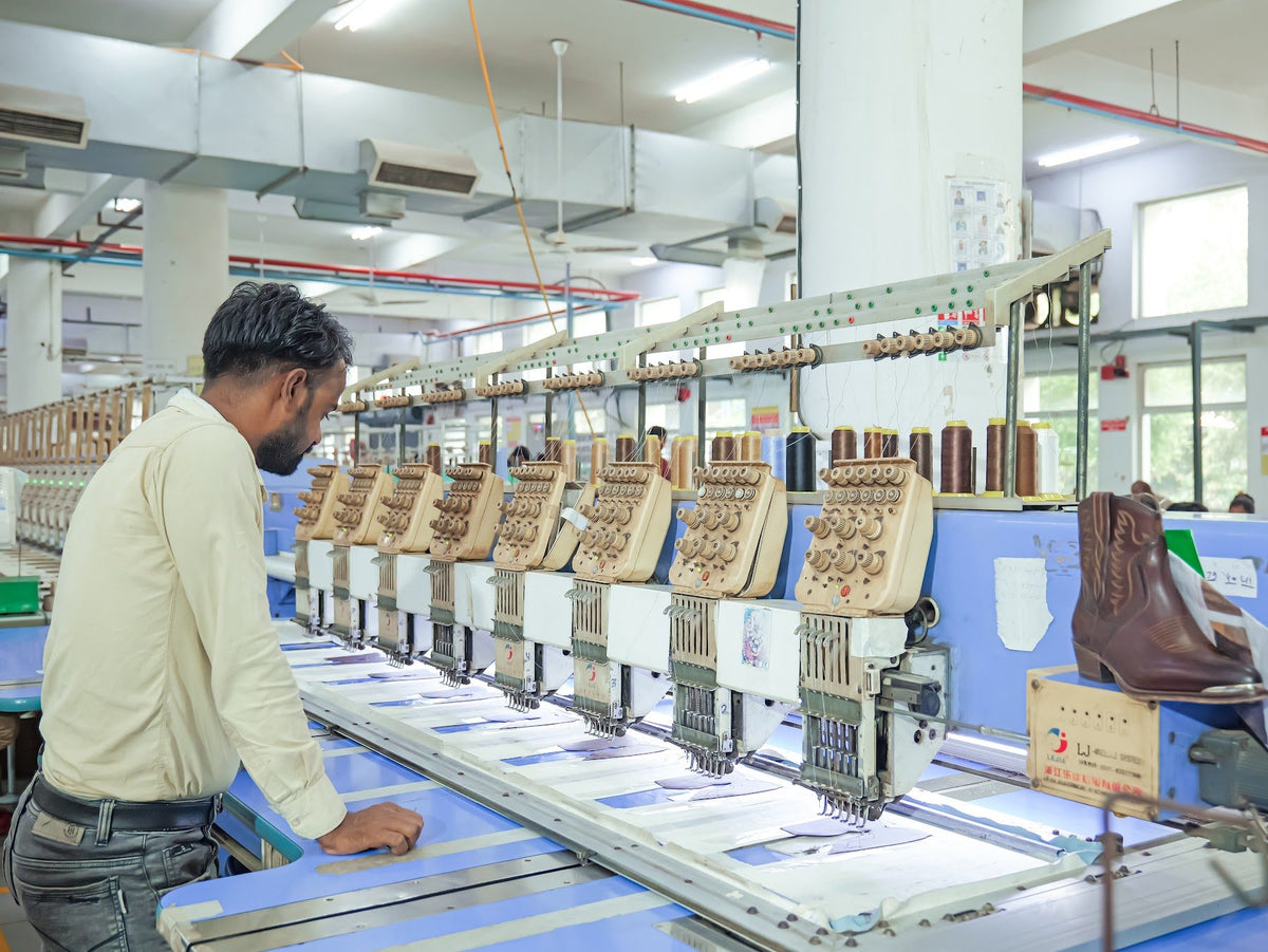 An operator at a row of multi-head embroidery machines
