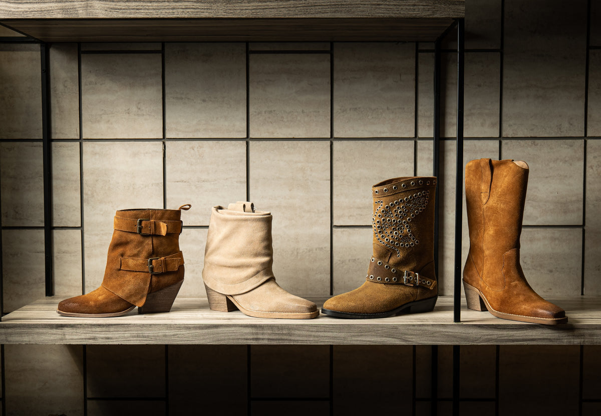 Fashion boots in suede and leather displayed on a shelf