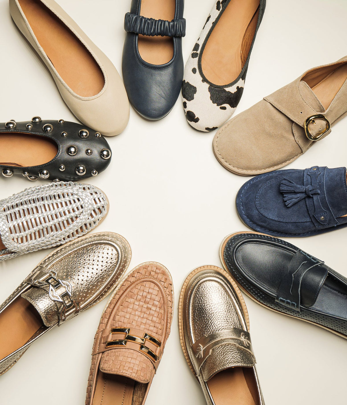 Women’s flats, loafers and Mary Janes in leather, suede, weave and metallic finishes, laid out in a circle