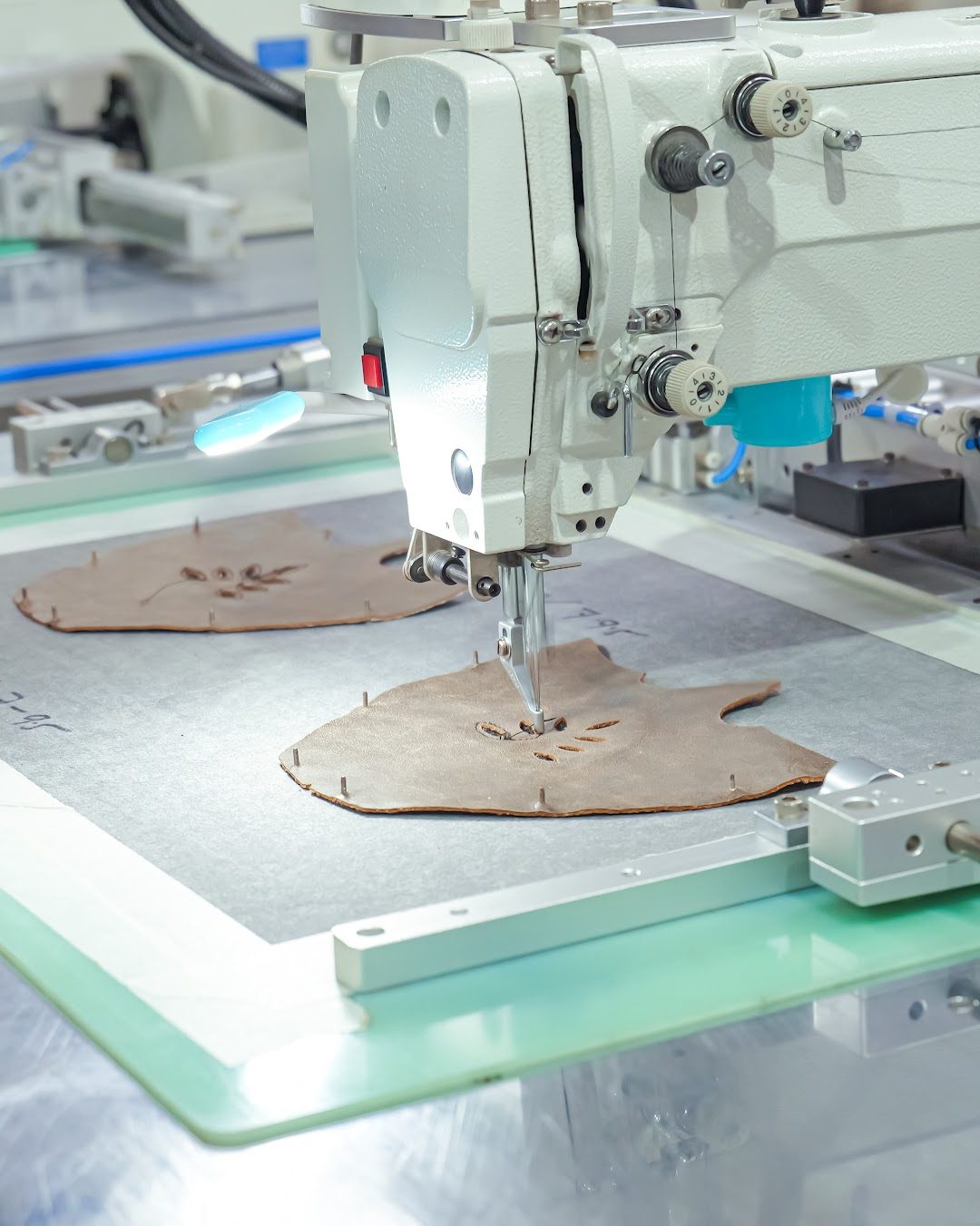 An automatic stitching machine sewing a leather upper panel