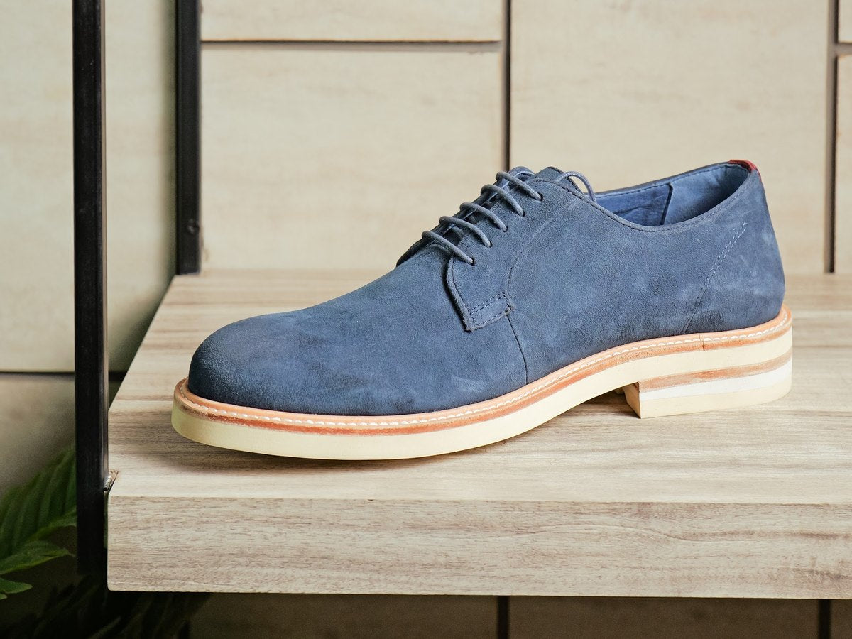 A blue suede men’s derby on a showroom shelf