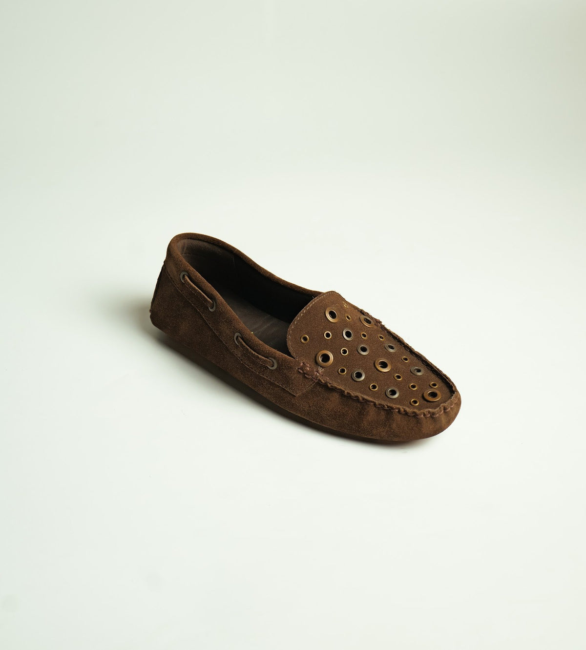 A brown suede driving moccasin with metal eyelets