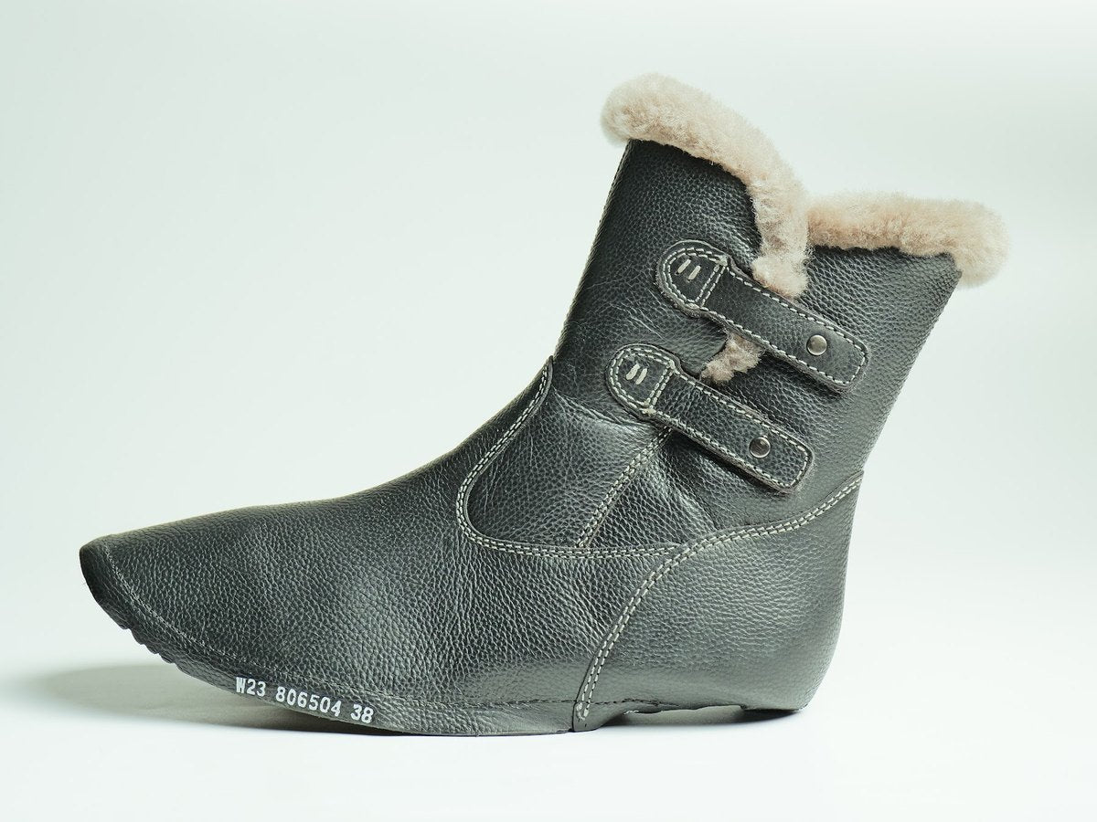 A leather boot upper with a lamb fur collar and twin straps