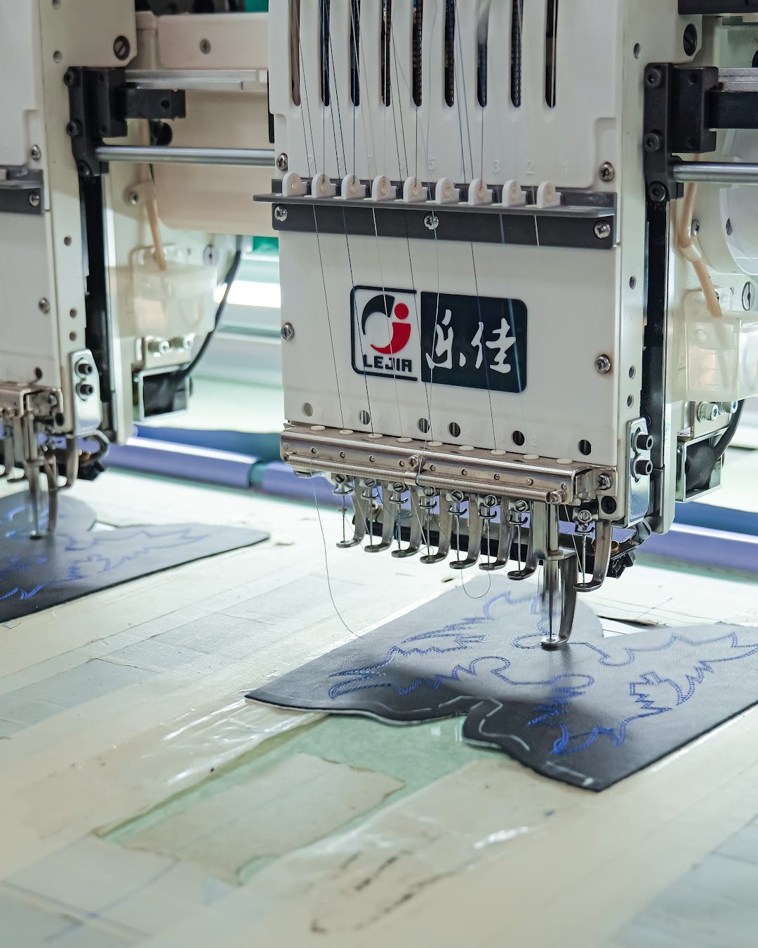 Multi-head embroidery stitching a pattern onto a leather panel