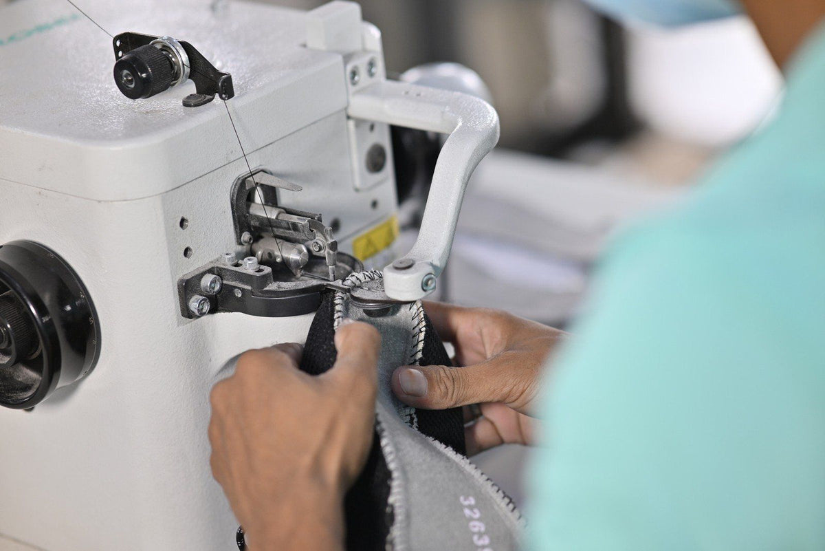 An operator guiding an upper through a Strobel machine