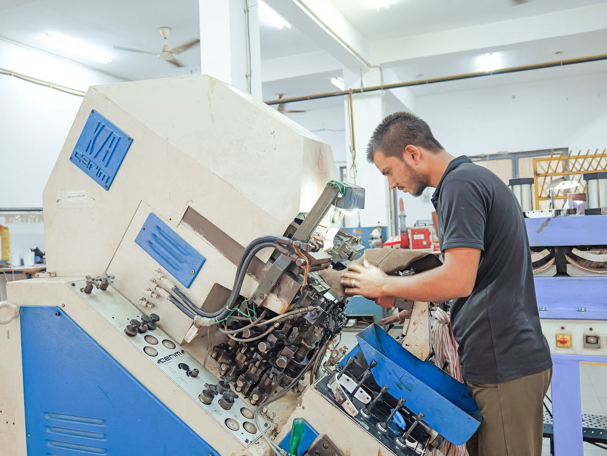 An operator at lasting and moulding machinery on the AFPL line