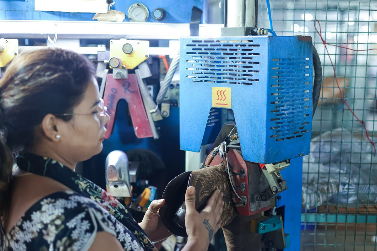 An operator lasting a Western boot on a toe-lasting machine