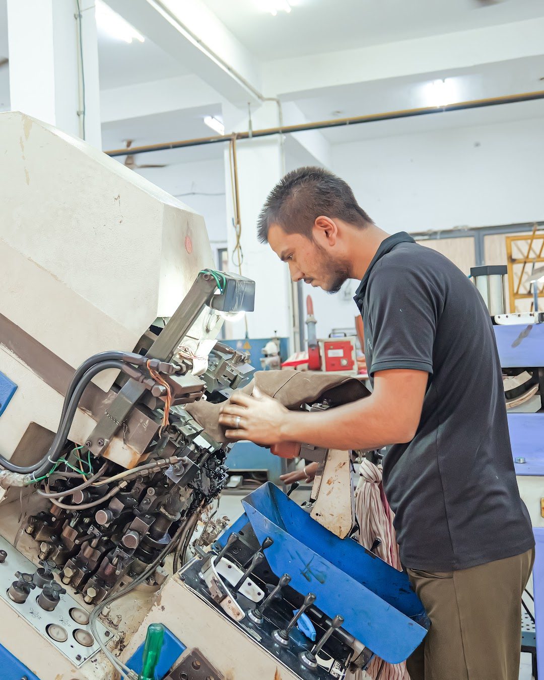 An operator shaping a boot upper on a moulding machine