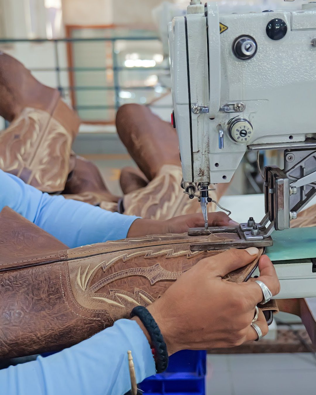 An operator stitching a decorated Western boot shaft