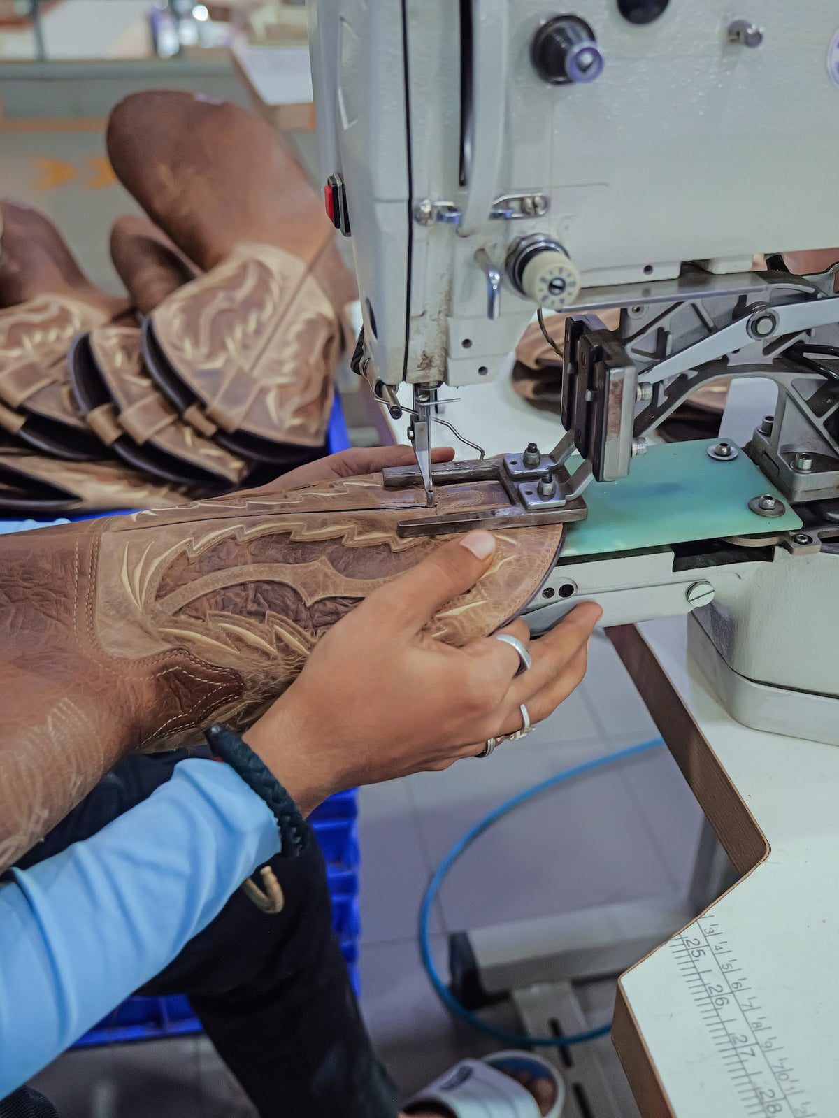 An operator stitching an embroidered Western boot shaft