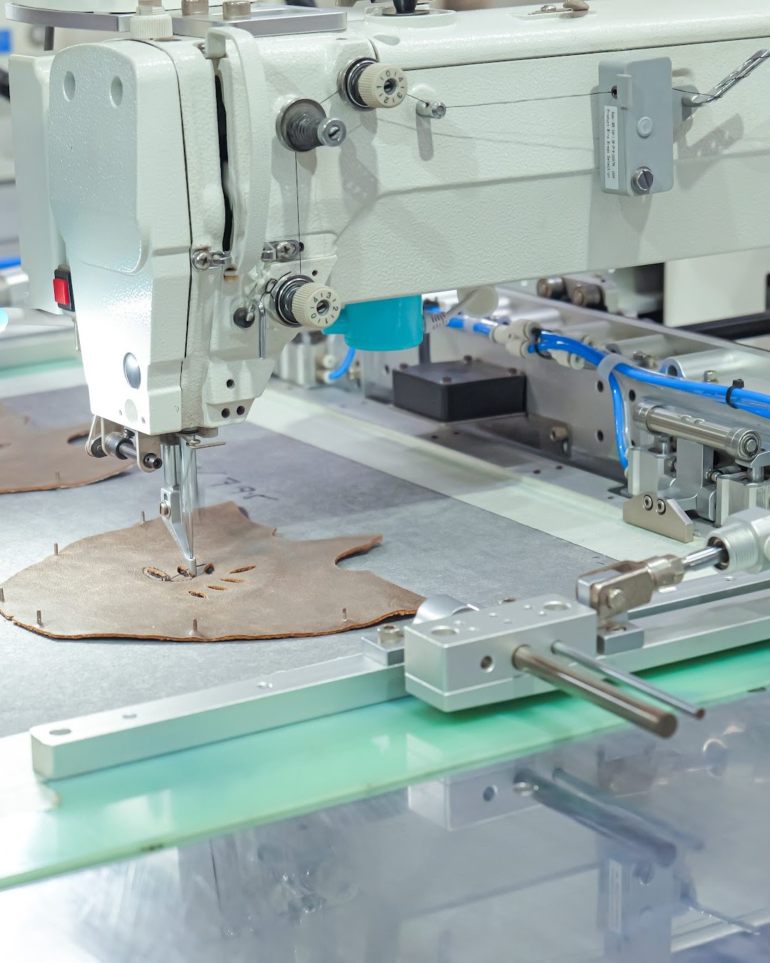 A programmable stitching machine working an upper component