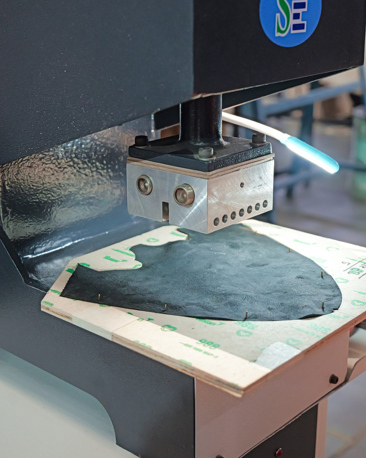 A punching press working on a leather upper component