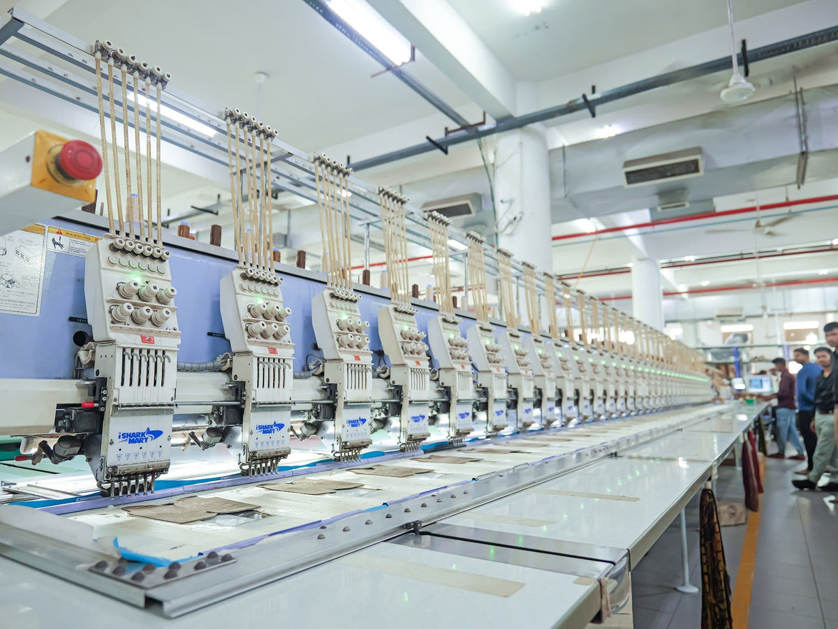 A row of computerised multi-head embroidery machines on an AFPL production floor