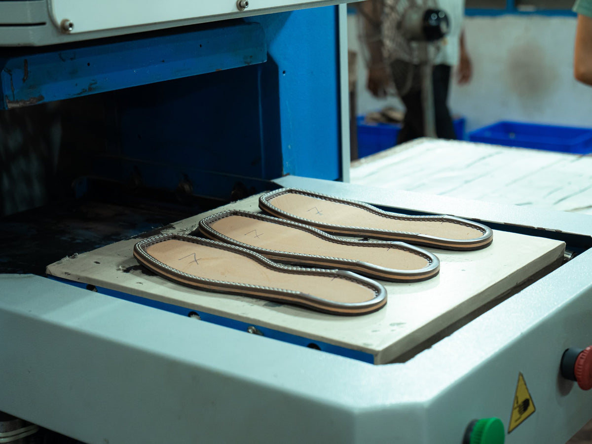 Footwear soles laid out on a press bed in the AFPL Sole Unit