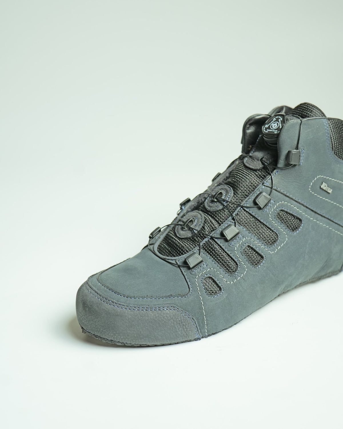 A suede shoe with a dial-operated auto-lacing closure, made by AFPL