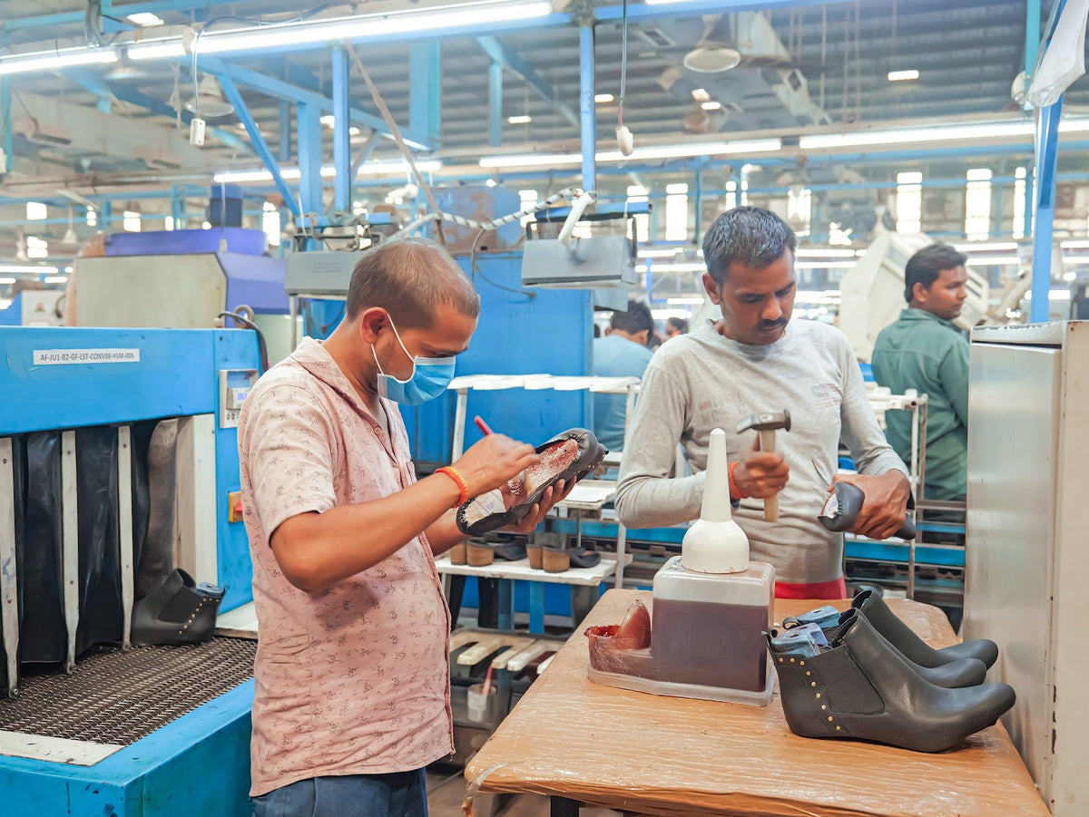 Two AFPL team members finishing boots at a work table