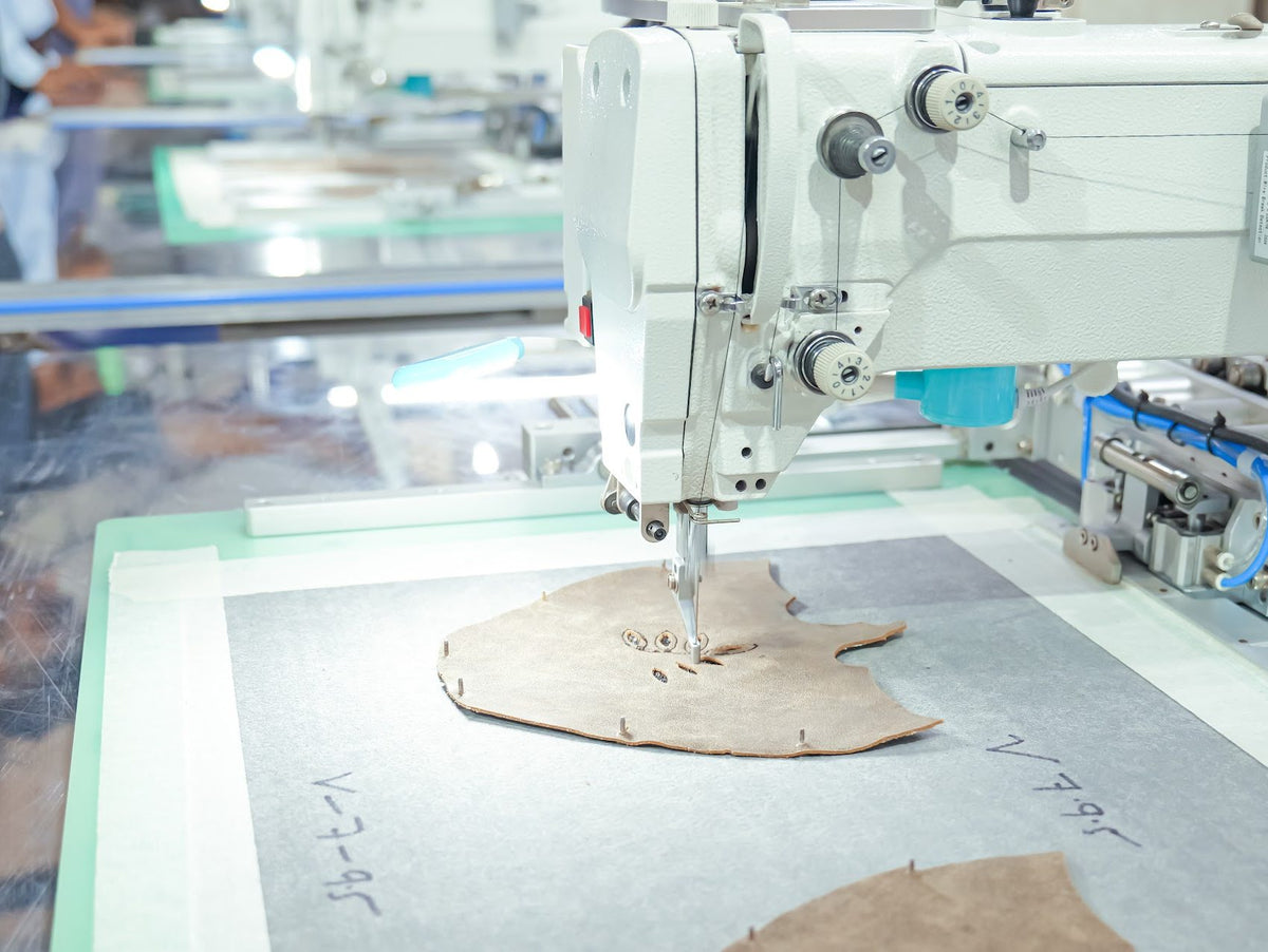 A programmable pattern tacker stitching an upper component