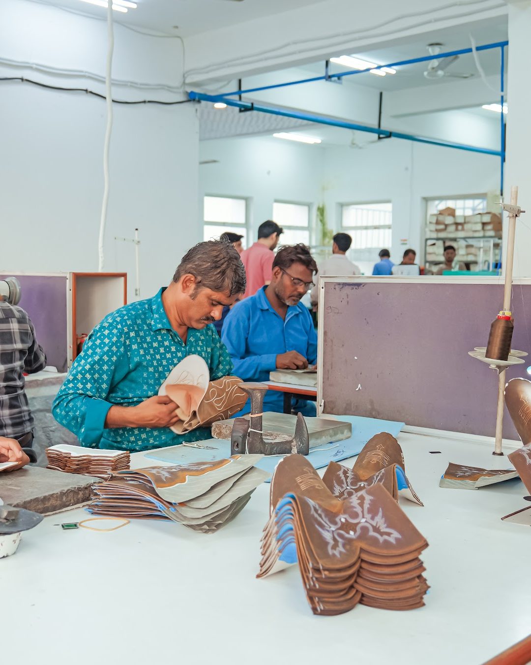 Upper-passing teams reviewing embroidered Western boot uppers