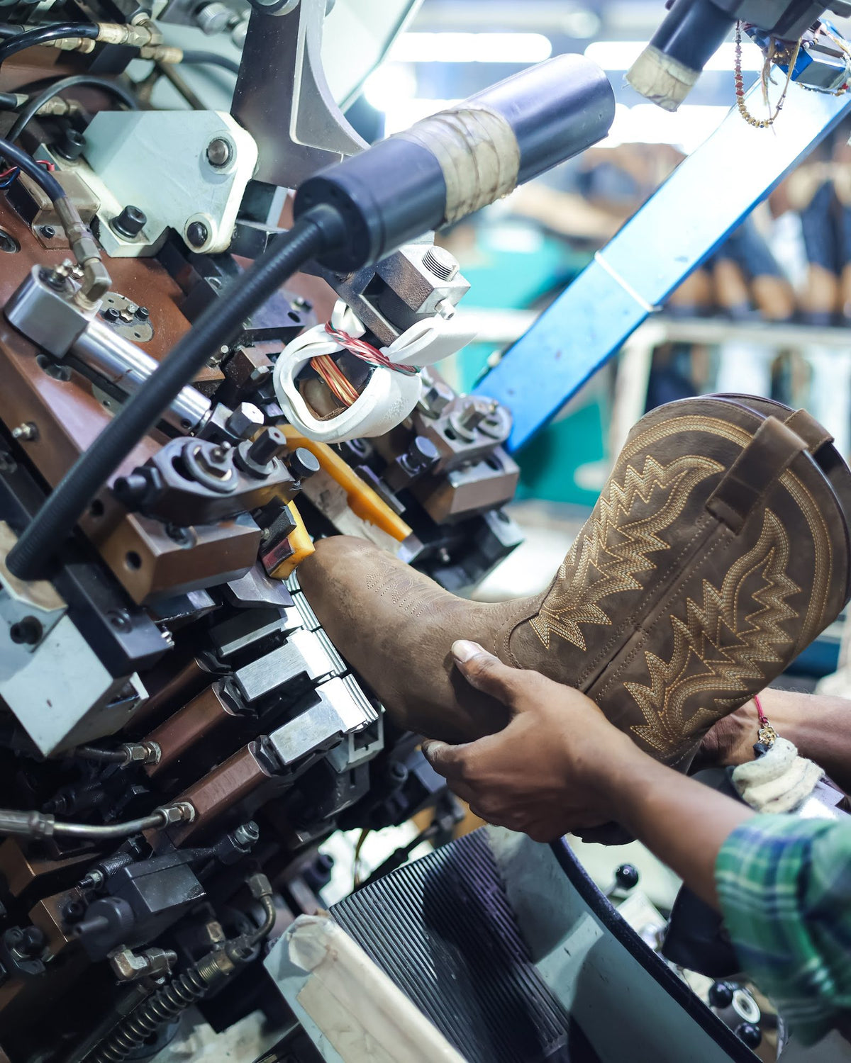A Western boot held in a lasting machine