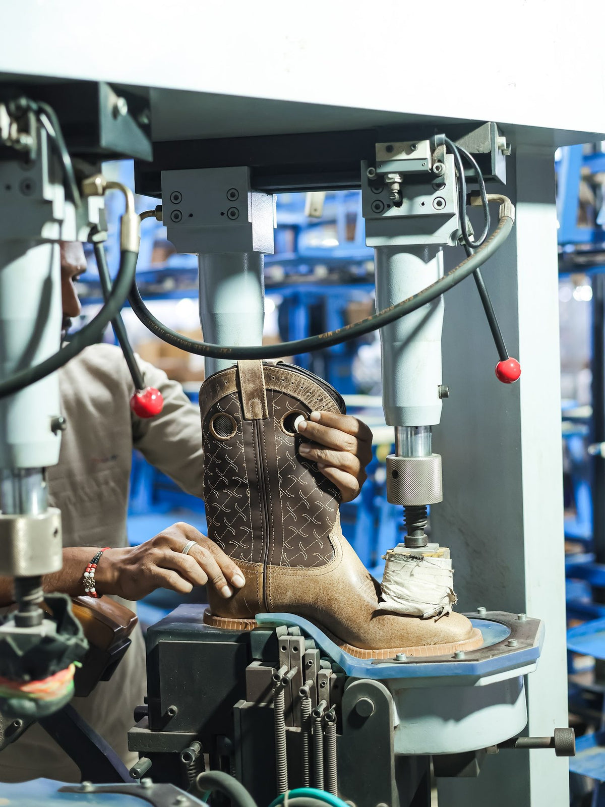 A Western boot in a sole-attaching press