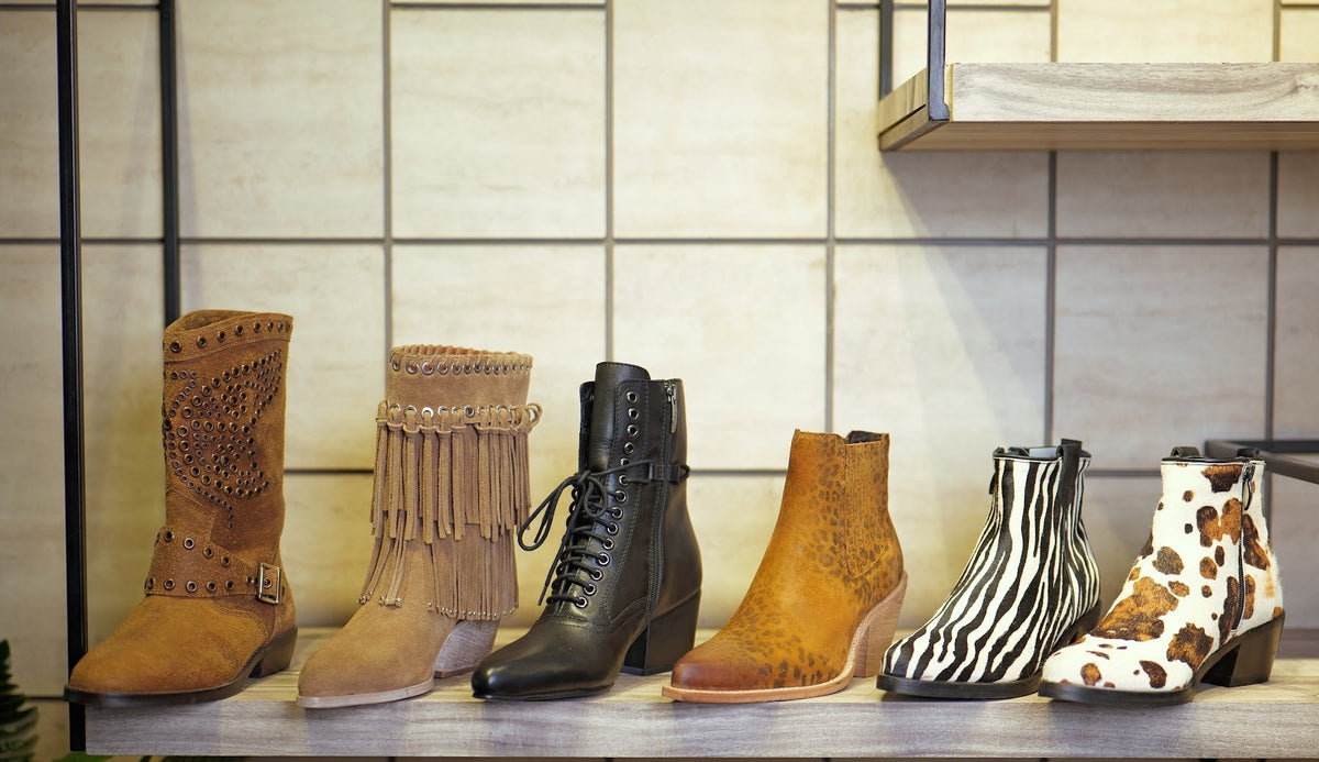 Women’s fashion boots side by side on a showroom shelf