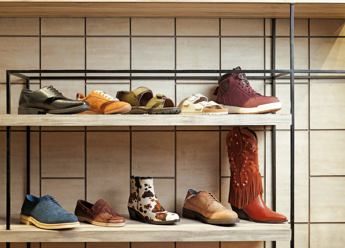 Women’s and men’s fashion footwear on showroom shelves, from loafers and sneakers to ankle and Western boots