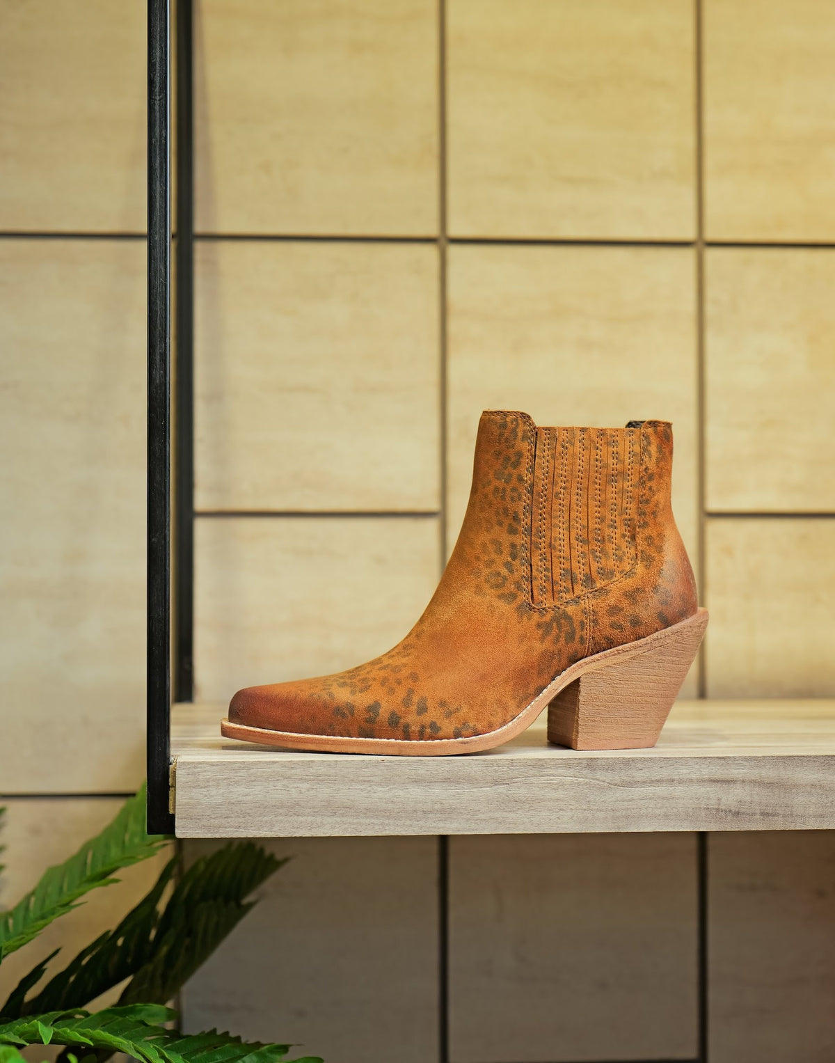 A women’s suede ankle boot on a showroom shelf